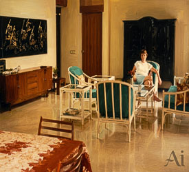 Interior of a Jakarta bungalow living room with wicker chairs, turquoise cushions, and a woman seated in afternoon light.